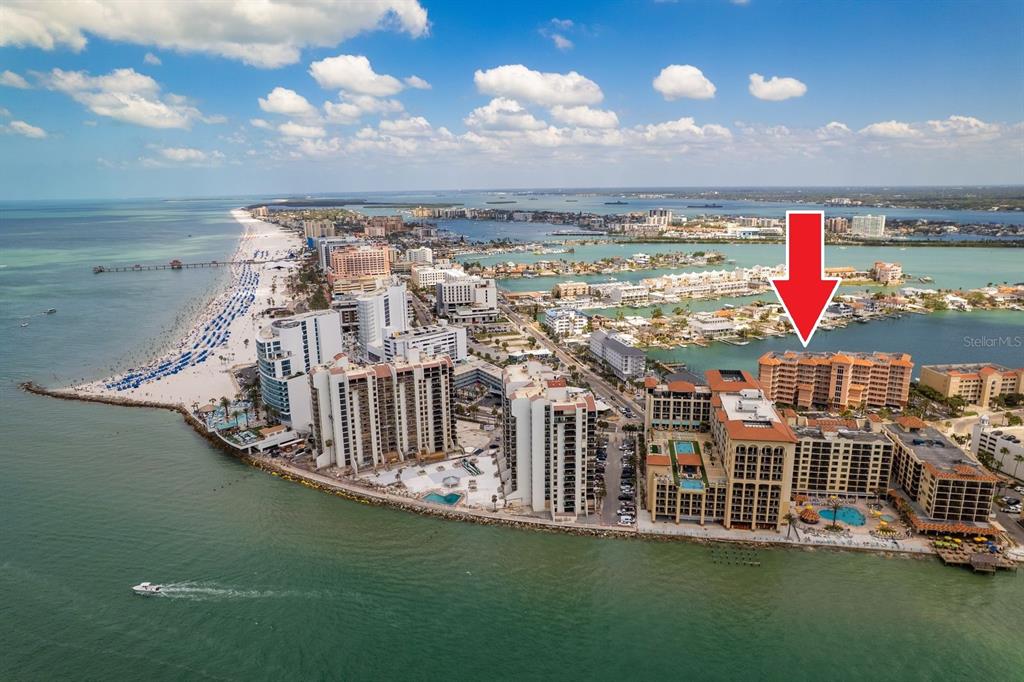 An aerial view of a multi-story waterfront condominium building with a boat dock and marina — 530 S GULFVIEW BOULEVARD UNIT 303, CLEARWATER, FL