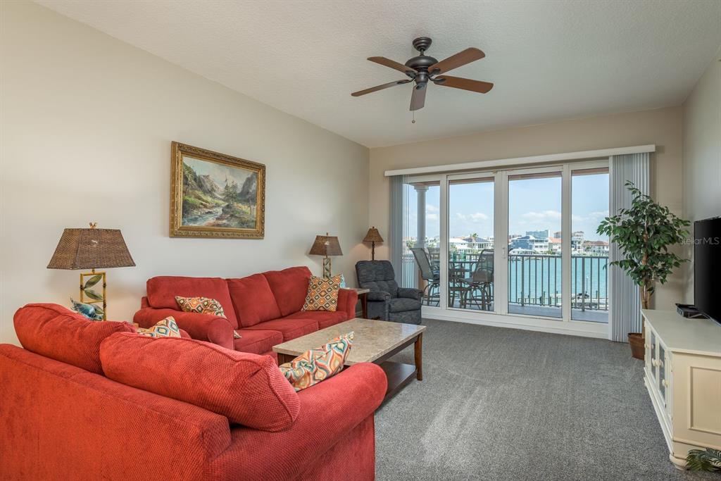 A balcony with patio furniture overlooks a waterway and buildings under a blue sky — 530 S GULFVIEW BOULEVARD UNIT 303, CLEARWATER, FL