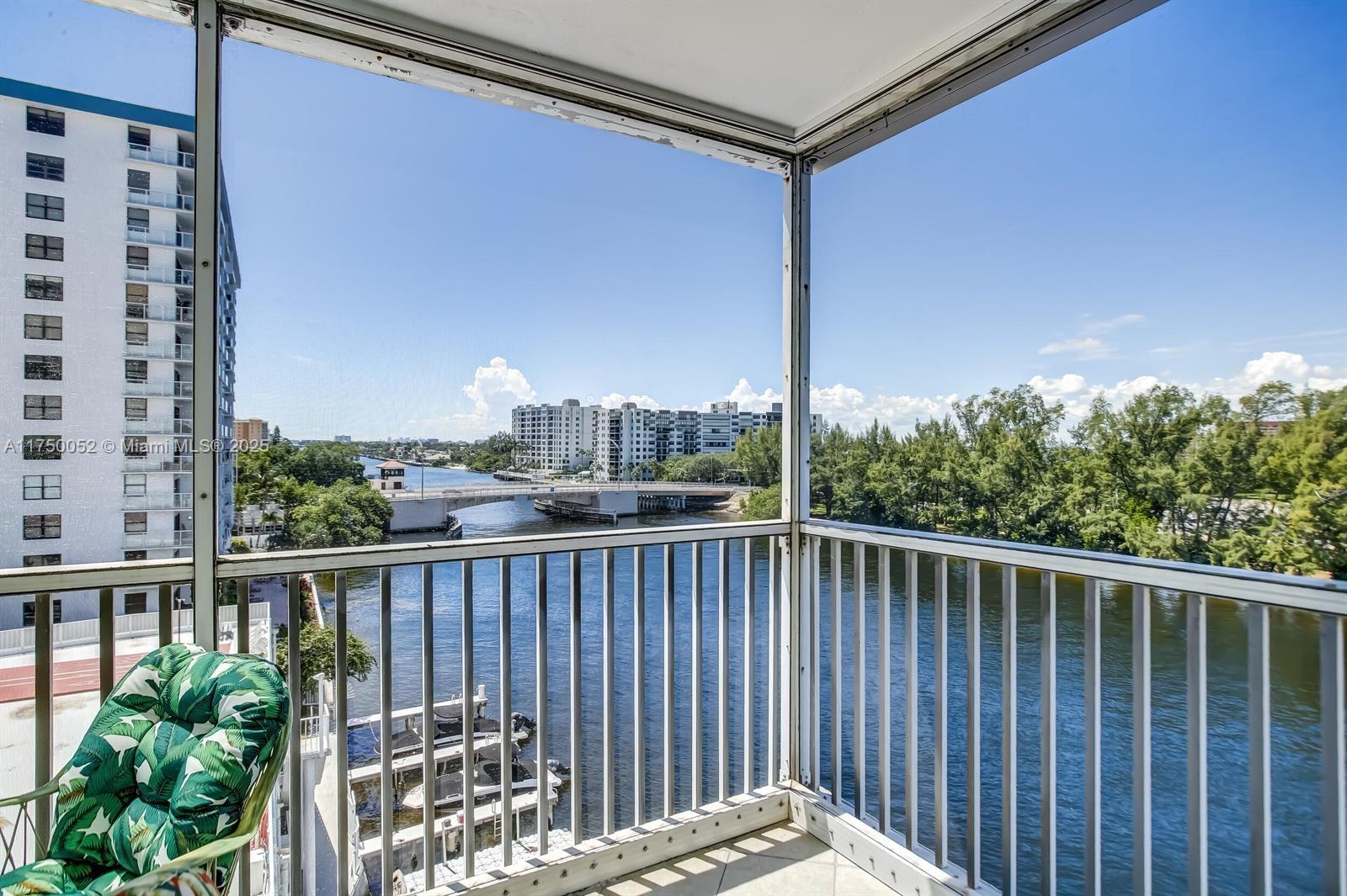 A screened-in balcony overlooks a river, a bridge, and nearby apartment buildings — 1505 N Riverside Dr # 604, Pompano Beach FL 33062, POMPANO BEACH, FL