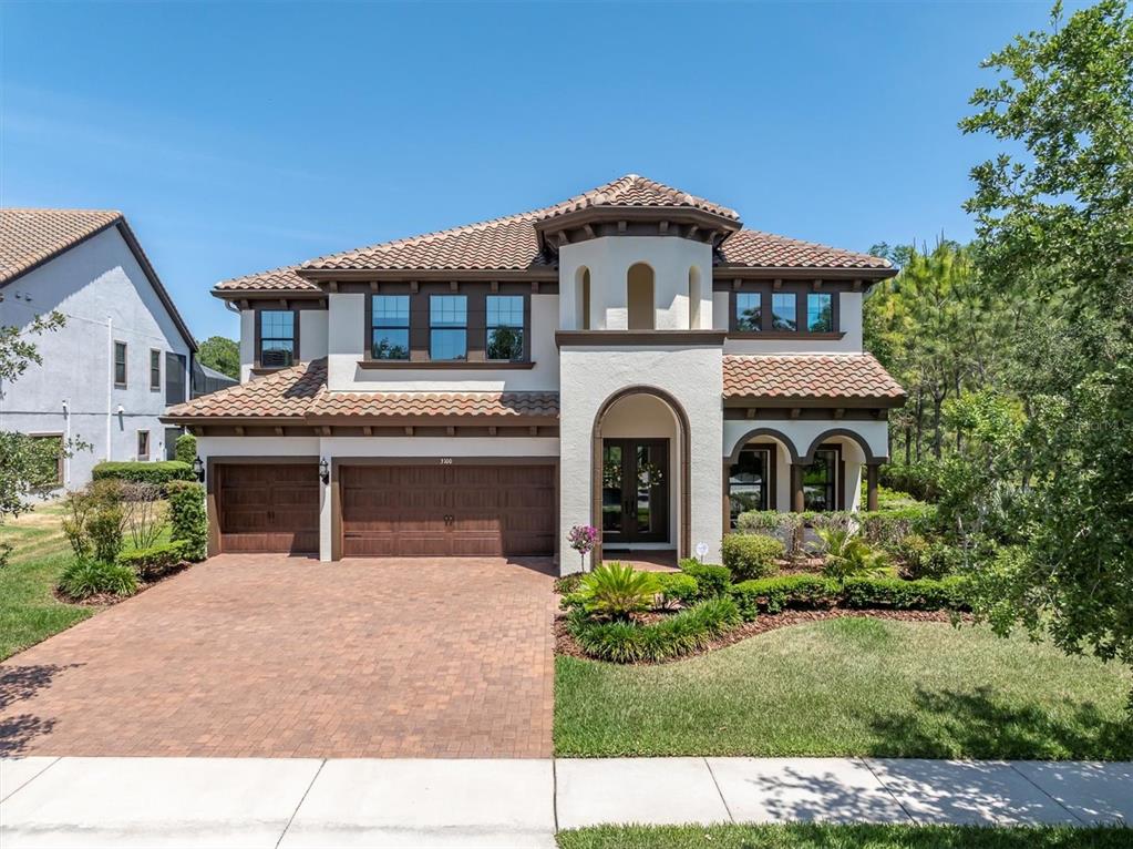 A two-story house with a tile roof, stucco exterior, and a three-car garage — 3100 BARBOUR TRAIL, ODESSA, FL
