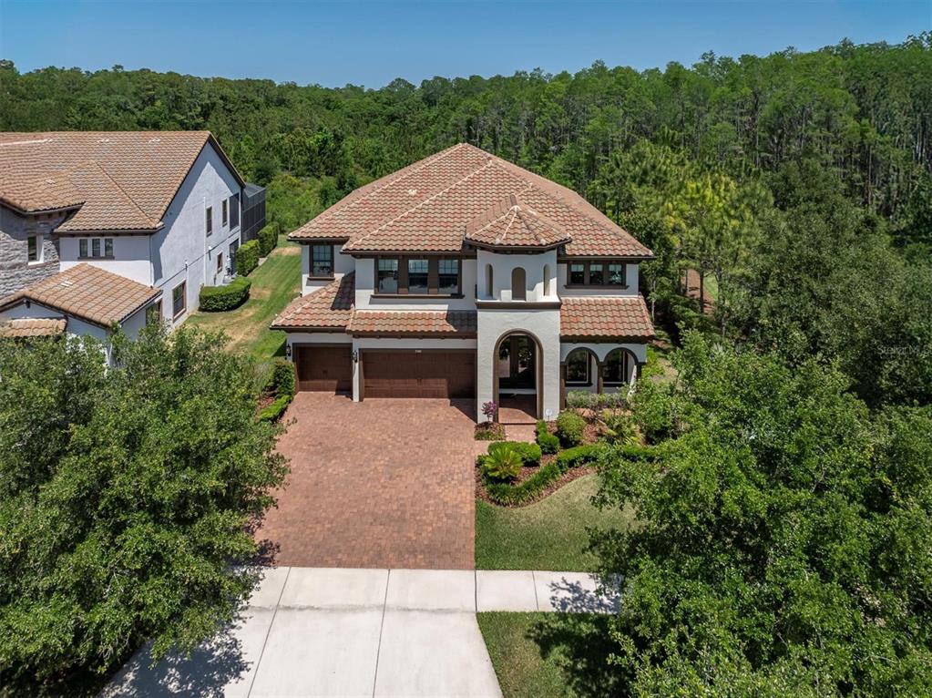 An aerial view of a two-story suburban house with a tile roof and brick driveway — 3100 BARBOUR TRAIL, ODESSA, FL