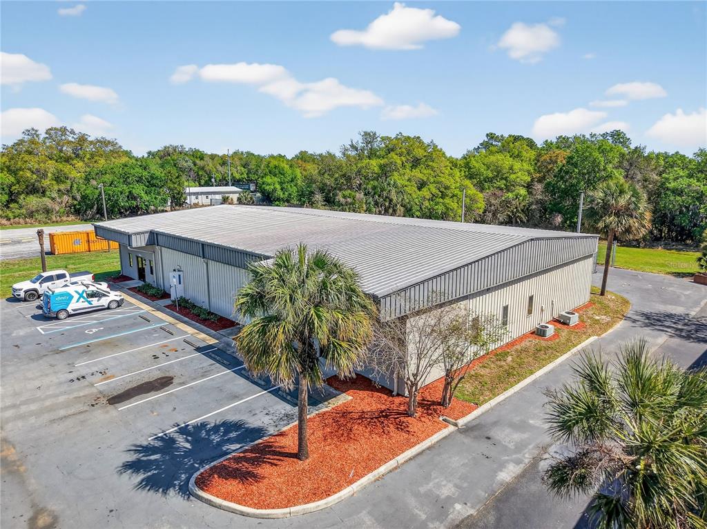An aerial view of a metal-sided commercial building with a parking lot and palm trees — 300 RICHEY ROAD UNIT 3 & 4, LEESBURG, FL