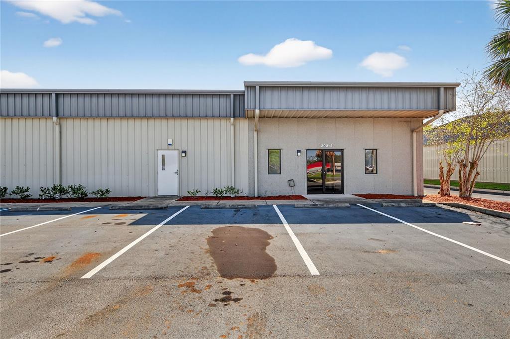 A commercial building exterior features a metal facade, a glass entrance door, and parking spaces — 300 RICHEY ROAD UNIT 3 & 4, LEESBURG, FL