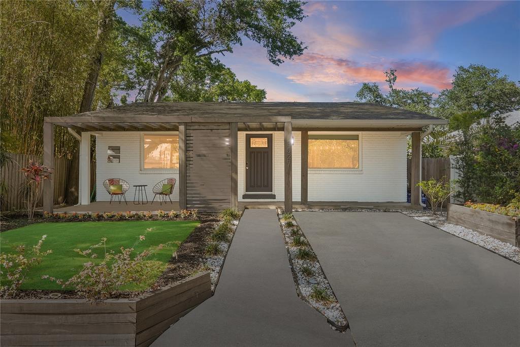 A single-story house with a white brick exterior, a front porch, and a concrete driveway — 3027 BURLINGTON AVENUE N, ST PETERSBURG, FL