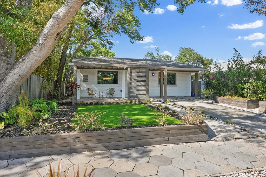 A white brick house with a wooden pergola, front patio, and a small green lawn — 3027 BURLINGTON AVENUE N, ST PETERSBURG, FL