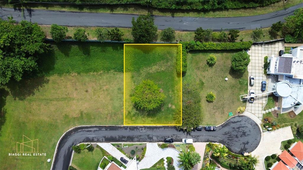 An aerial view shows a rectangular plot of land highlighted in yellow within a neighborhood — LAS VISTA, LOT.24, RIO MAR, RIO GRANDE, PR