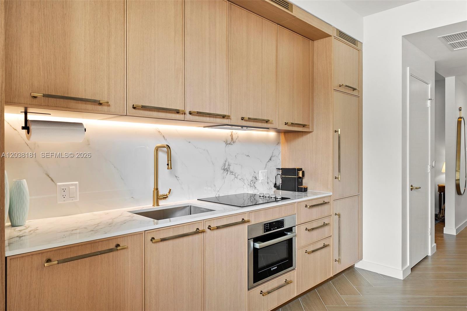 A modern kitchen features light wood cabinetry, white marble countertops, and gold-toned hardware — 2700 NW 2nd Ave # 532, Miami FL 33127, MIAMI, FL