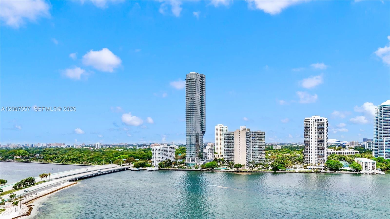 An aerial view shows a waterfront cityscape with a tall skyscraper and a bridge — 175 SE 25 Road # 803, Miami FL 33129, MIAMI, FL