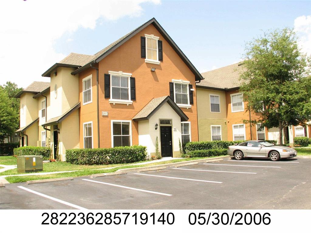 A two-story apartment building with tan and orange stucco siding and a parking lot — 5957 WESTGATE DRIVE UNIT 1914, ORLANDO, FL