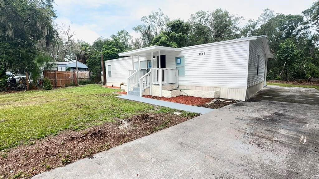 A white single-wide mobile home features a front porch with stairs and a concrete driveway — 3545 SHADY BROOKE COURT, MULBERRY, FL