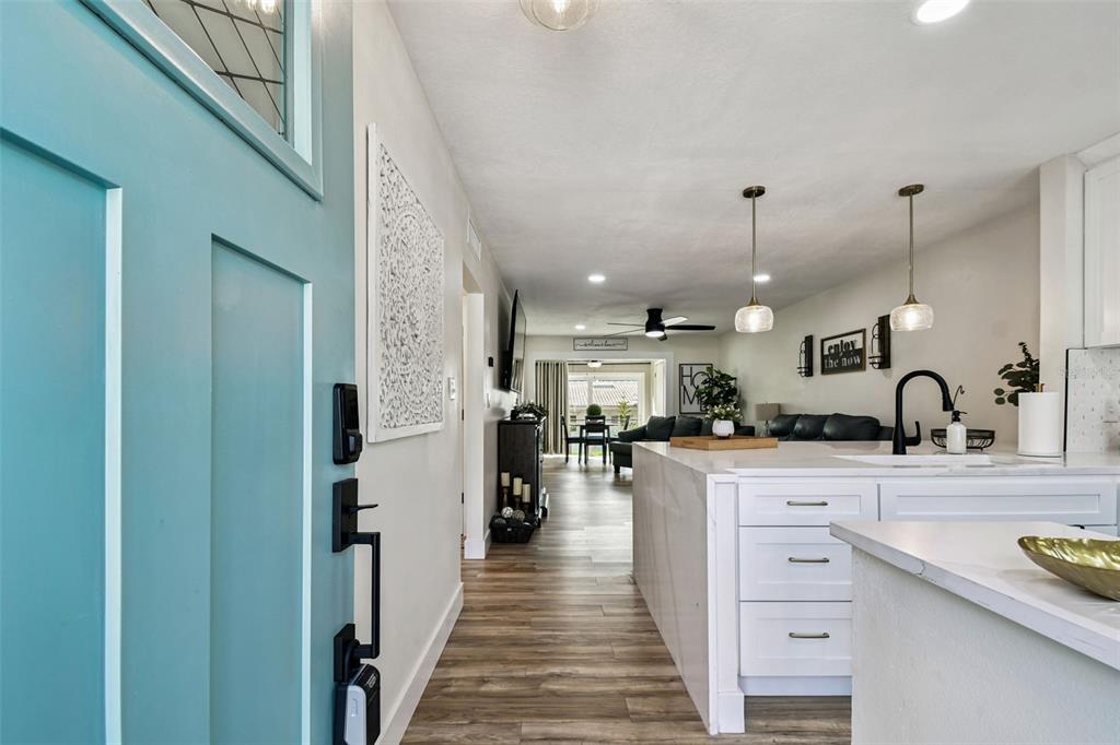 A view from a teal front door into a kitchen and open-concept living area — 9032 MISSION OAKS BOULEVARD UNIT F, SEMINOLE, FL