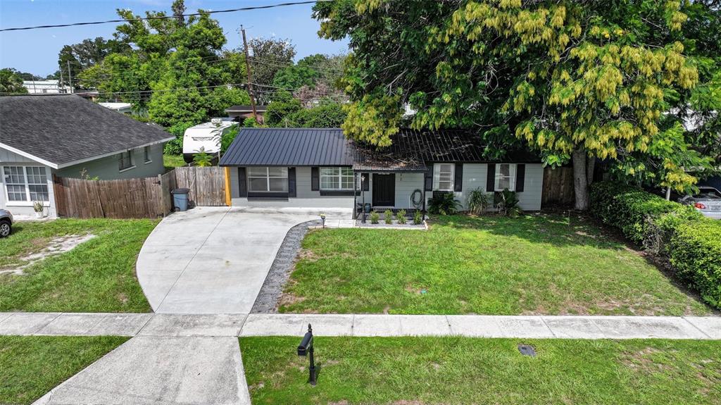 A single-story house with a metal roof, gray siding, and a concrete driveway — 1611 SMITHFIELD CIRCLE W, LAKELAND, FL