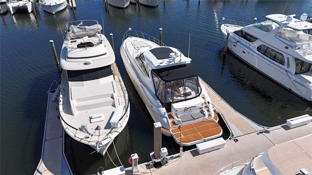 An aerial view shows three yachts docked at a marina with wooden pilings — 102 RIVIERA DUNES WAY UNIT S-21, PALMETTO, FL