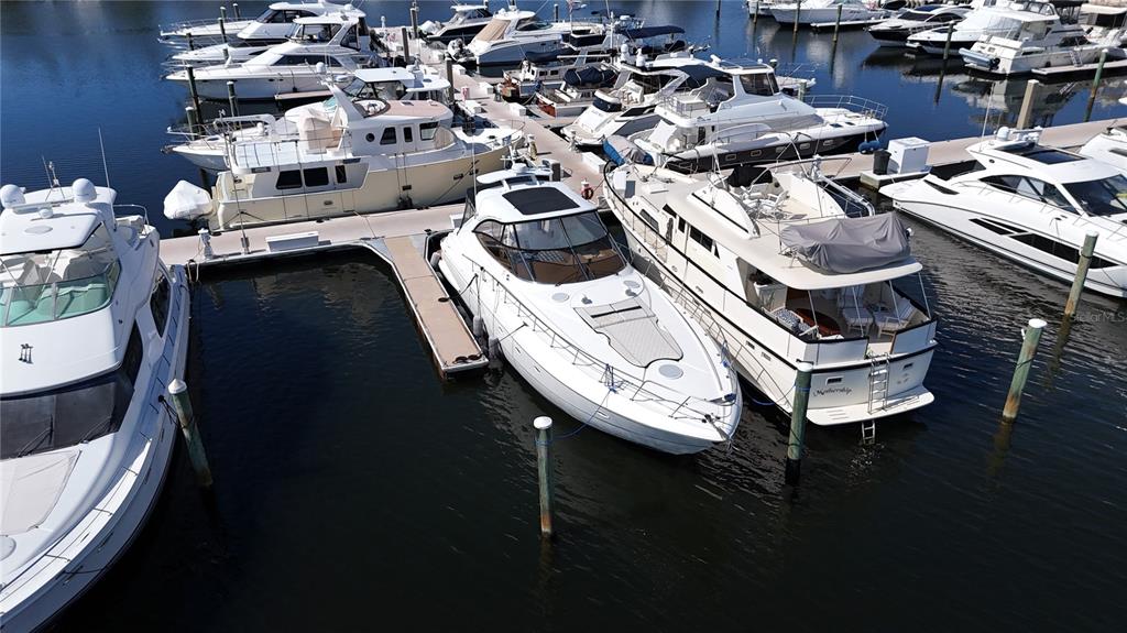 An aerial view shows several white yachts docked at a marina on calm water — 102 RIVIERA DUNES WAY UNIT S-21, PALMETTO, FL