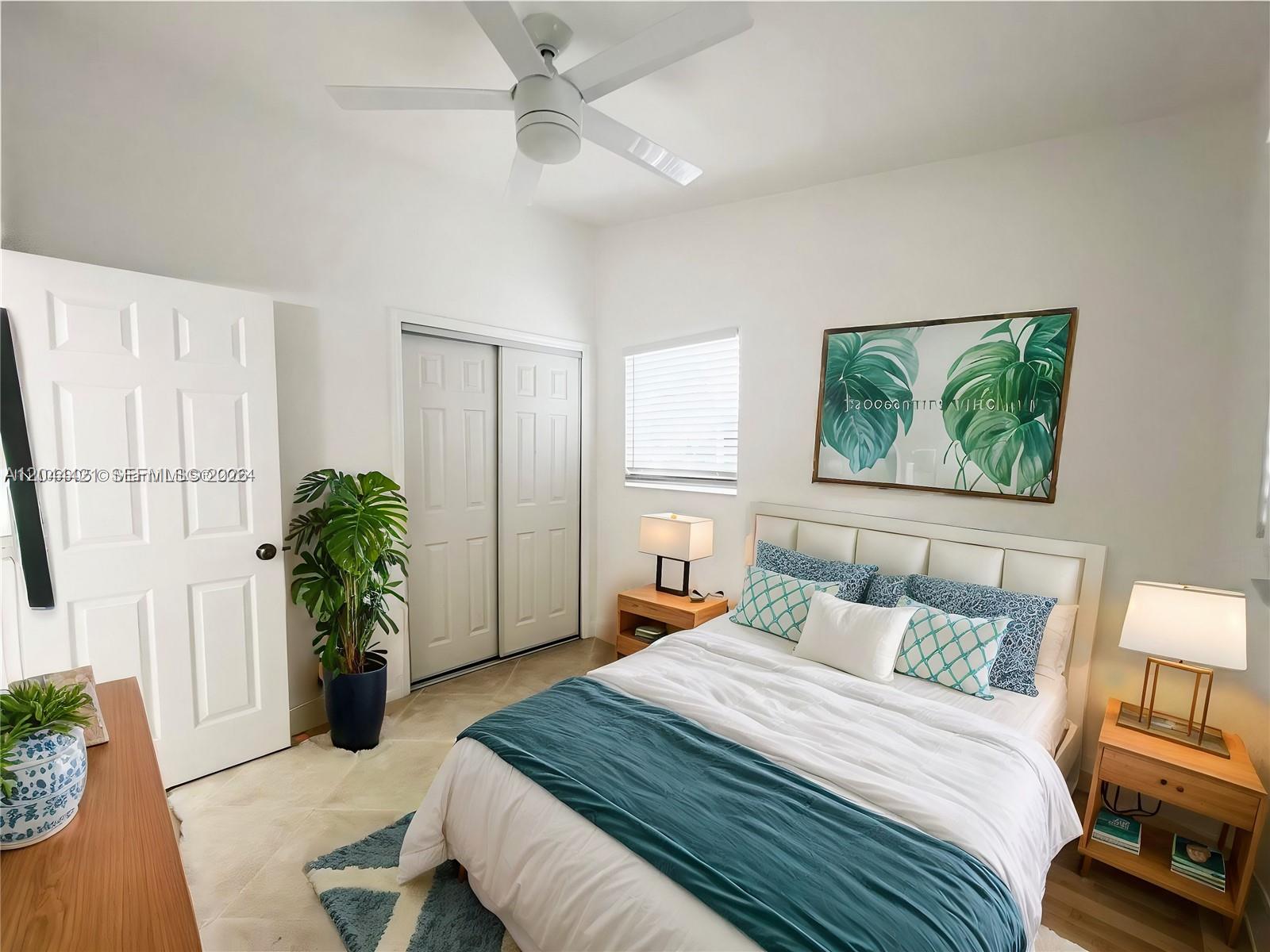 A bedroom features a white bed with teal bedding, a ceiling fan, and a potted plant — 2679 NW 57th Ter, Margate FL 33063, MARGATE, FL