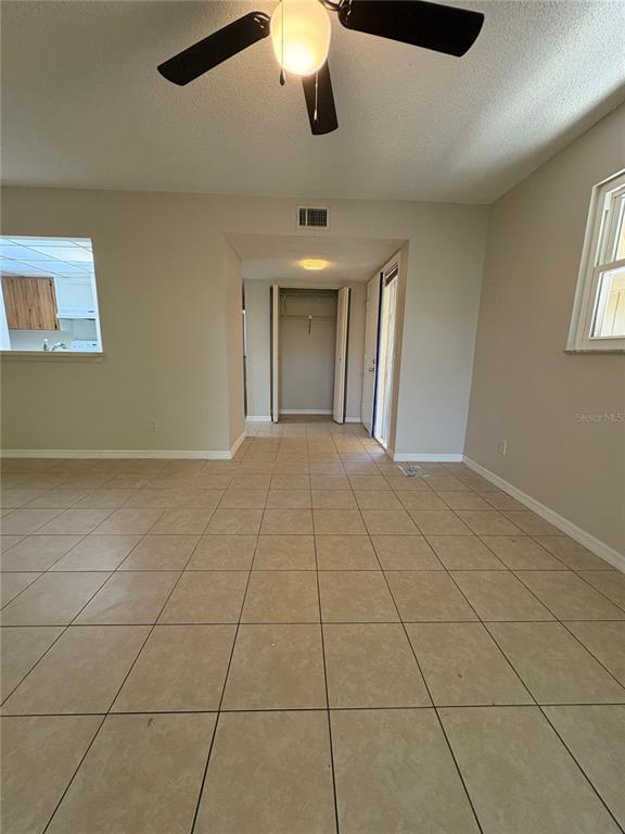 A room with light-colored tile flooring, a ceiling fan, and an open closet area — 140 ORCHID WOODS COURT UNIT 7D, DELTONA, FL
