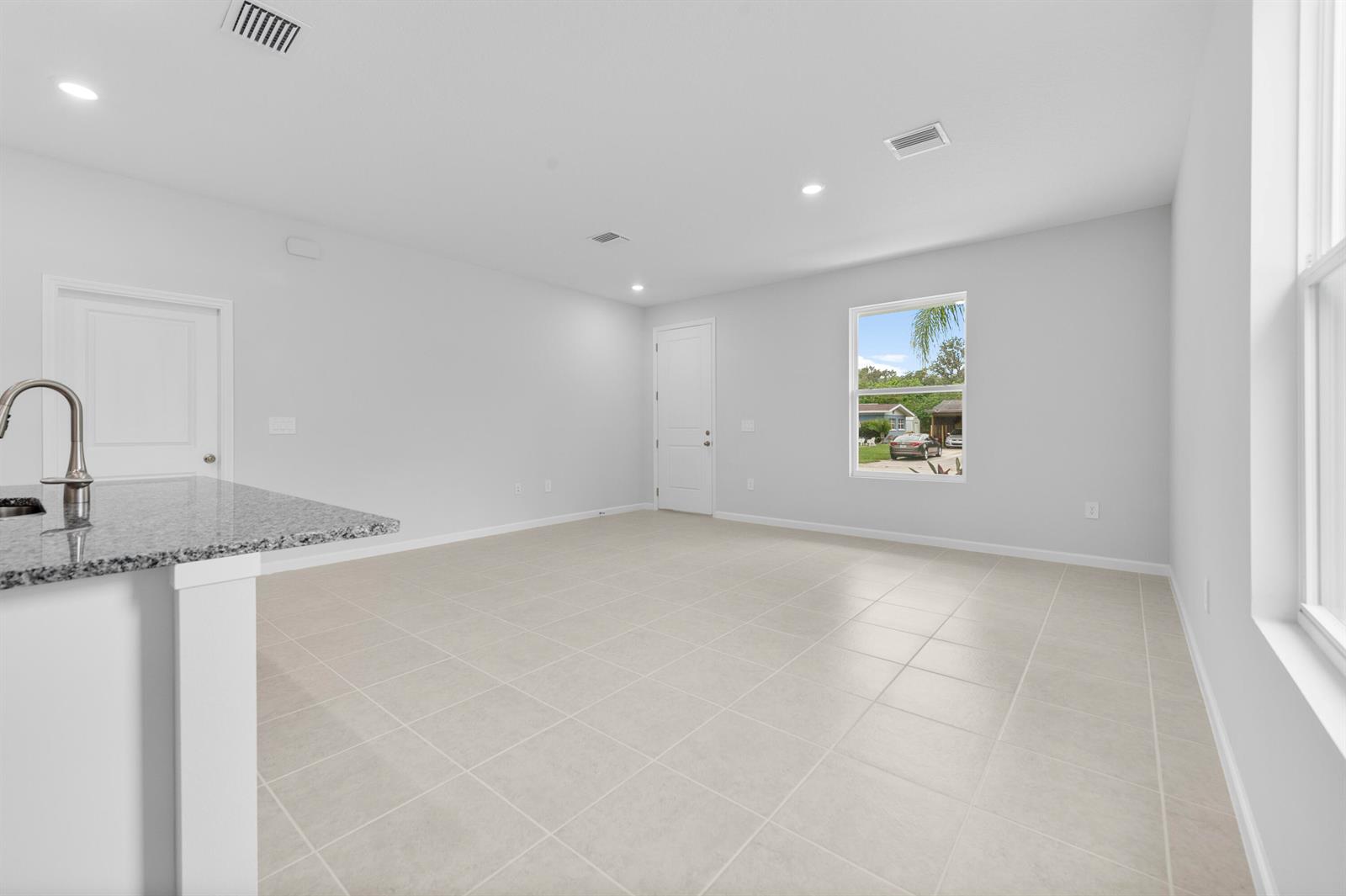 An open-concept room features light tile flooring, white walls, recessed lighting, and a kitchen island — 3344 N Park Drive, Fort Pierce FL 34982, FORT PIERCE, FL