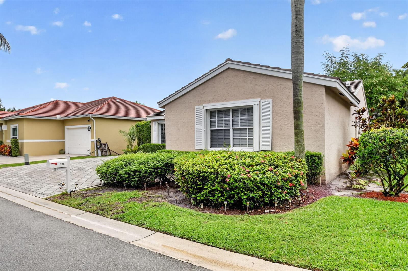 A tan single-story house with a tiled roof and a landscaped front yard — 208 Caribe Court, FL 33413, FL