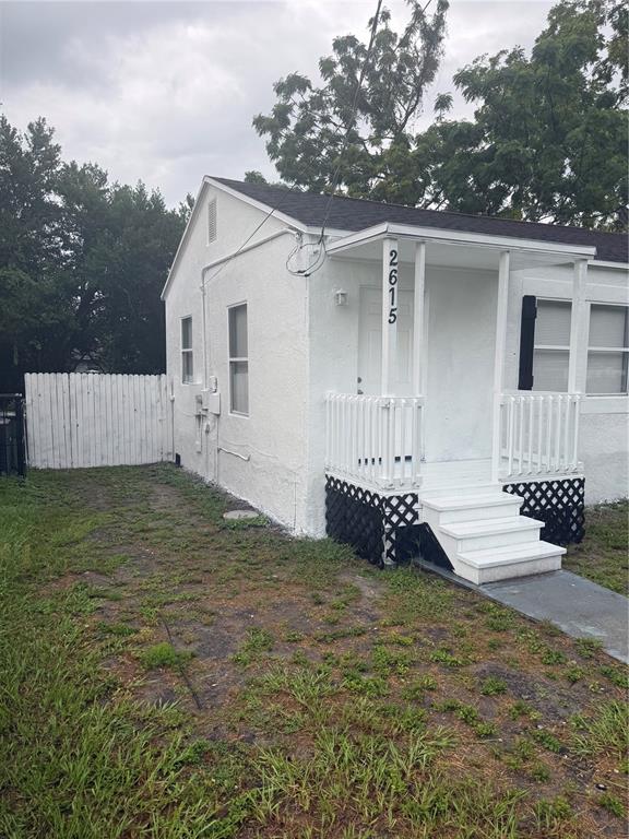 A small white house with a front porch, stairs, and a white wooden fence — 2615 E 28TH AVENUE, TAMPA, FL