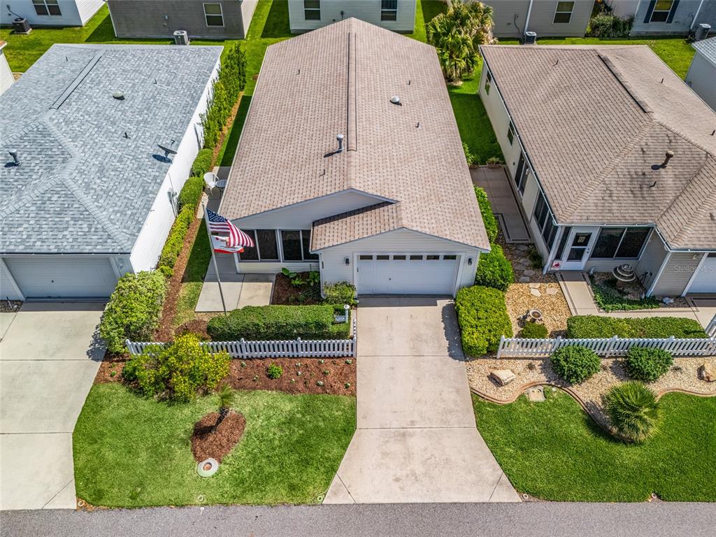 An aerial view of a single-story house with a driveway, garage, and small front yard — 2324 PICKENS PLACE, THE VILLAGES, FL
