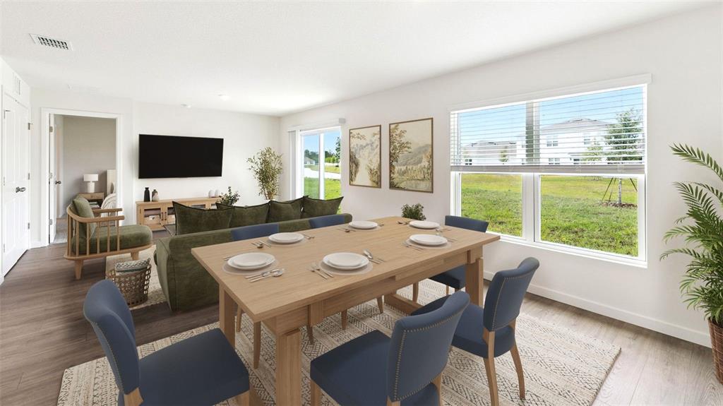This rendering shows a dining area with a wooden table and blue chairs near a living room — 1484 MORNING WALK DRIVE, ORMOND BEACH, FL