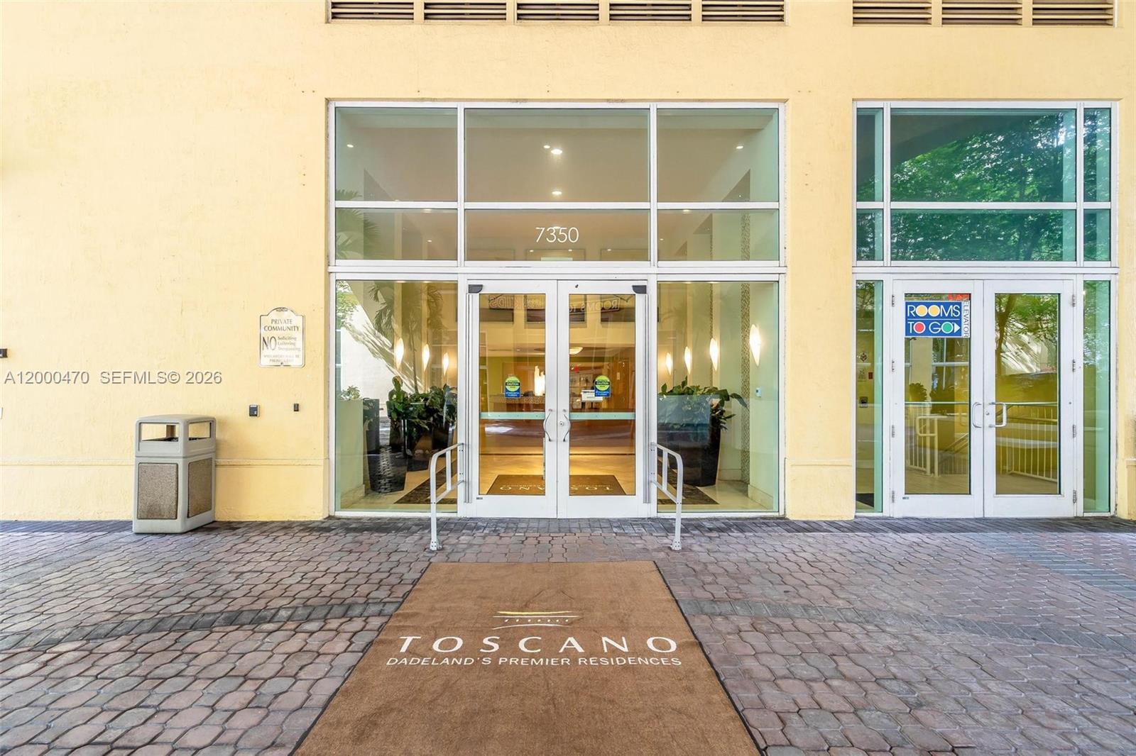 The exterior entrance of a building features glass double doors and a branded floor mat — 7350 SW 89th St # 1707S, Miami FL 33156, MIAMI, FL