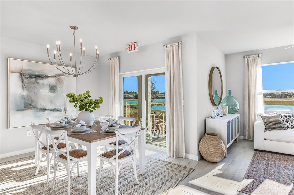 A dining area with a wooden table and white chairs sits beside a sliding glass door — 4924 TUSCOLA BOULEVARD, NORTH PORT, FL