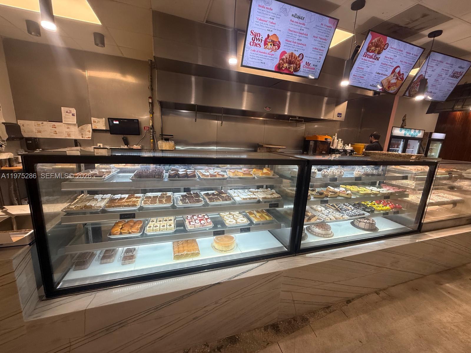 A bakery interior features a large glass display case filled with various pastries and desserts — Confidential NW 67th Ave, Hialeah FL 33015, HIALEAH, FL