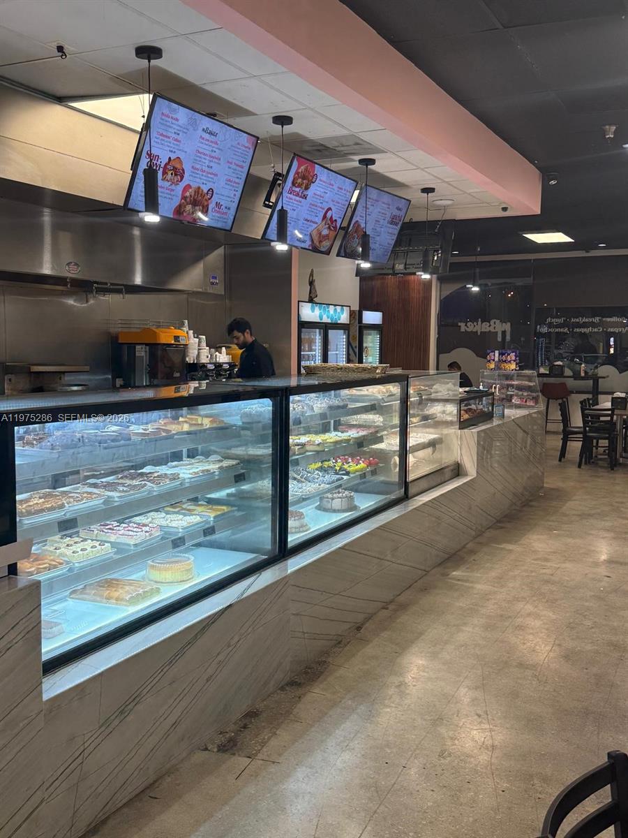 A bakery interior features glass display cases filled with pastries and digital menu boards overhead — Confidential NW 67th Ave, Hialeah FL 33015, HIALEAH, FL