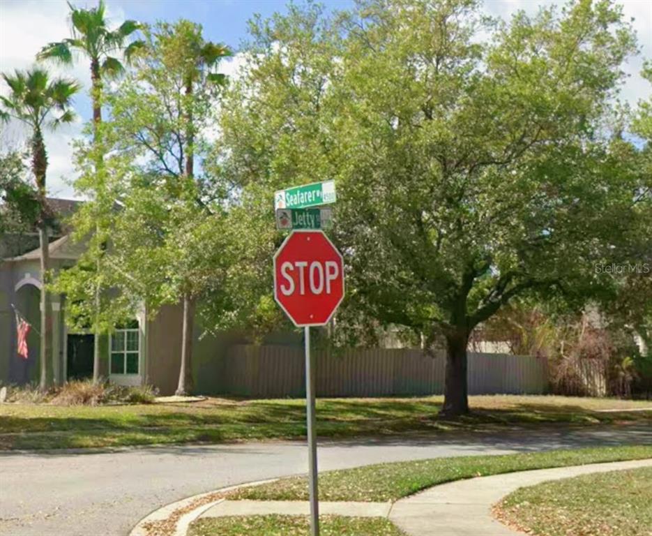 A stop sign stands at the intersection of Seafarer and Jetty streets near a residential home — SEAFARER WAY, ORLANDO, FL