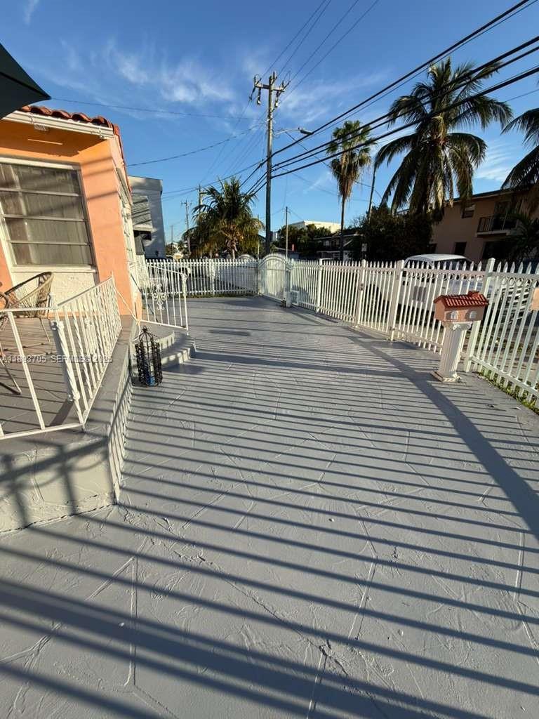 A paved patio area with a white metal fence and a mailbox on a pedestal — 300 NW 13th Ave, Miami FL 33125, MIAMI, FL