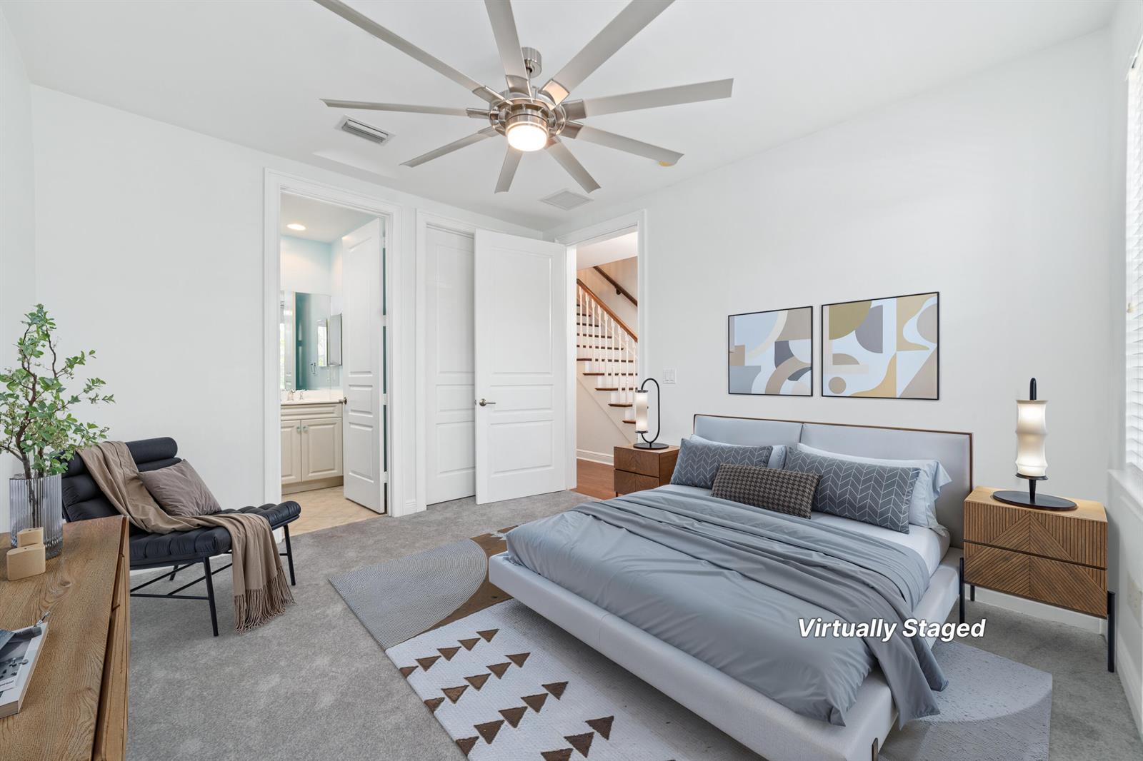 A bedroom with a ceiling fan, gray carpet, a bed, and an attached bathroom — 1002 E Heritage Club Circle, Delray Beach FL 33483, DELRAY BEACH, FL