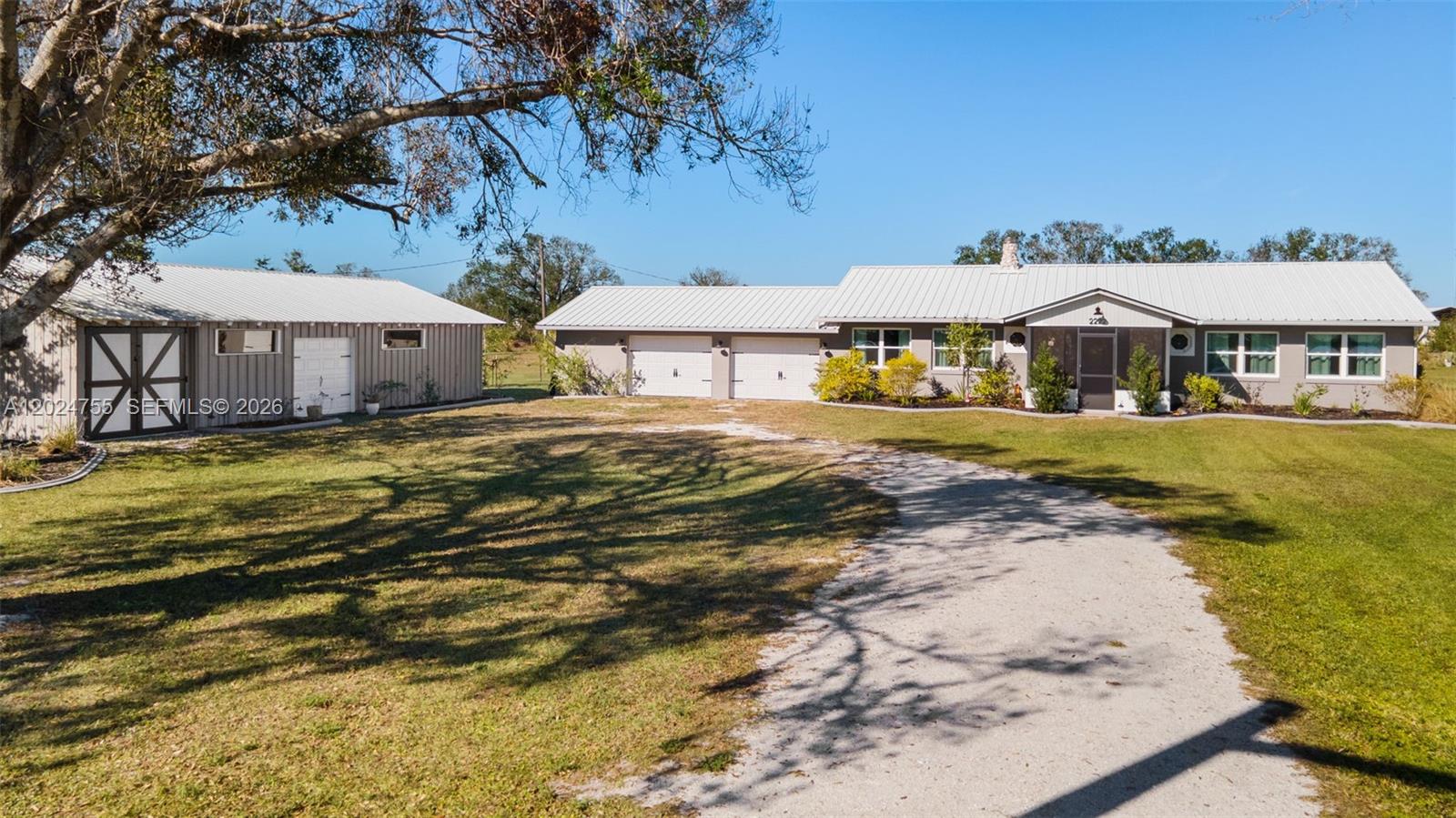 A single-story house with a metal roof, attached garage, and a separate detached workshop — OTHER CITY - IN THE STATE OF FLORIDA, FL