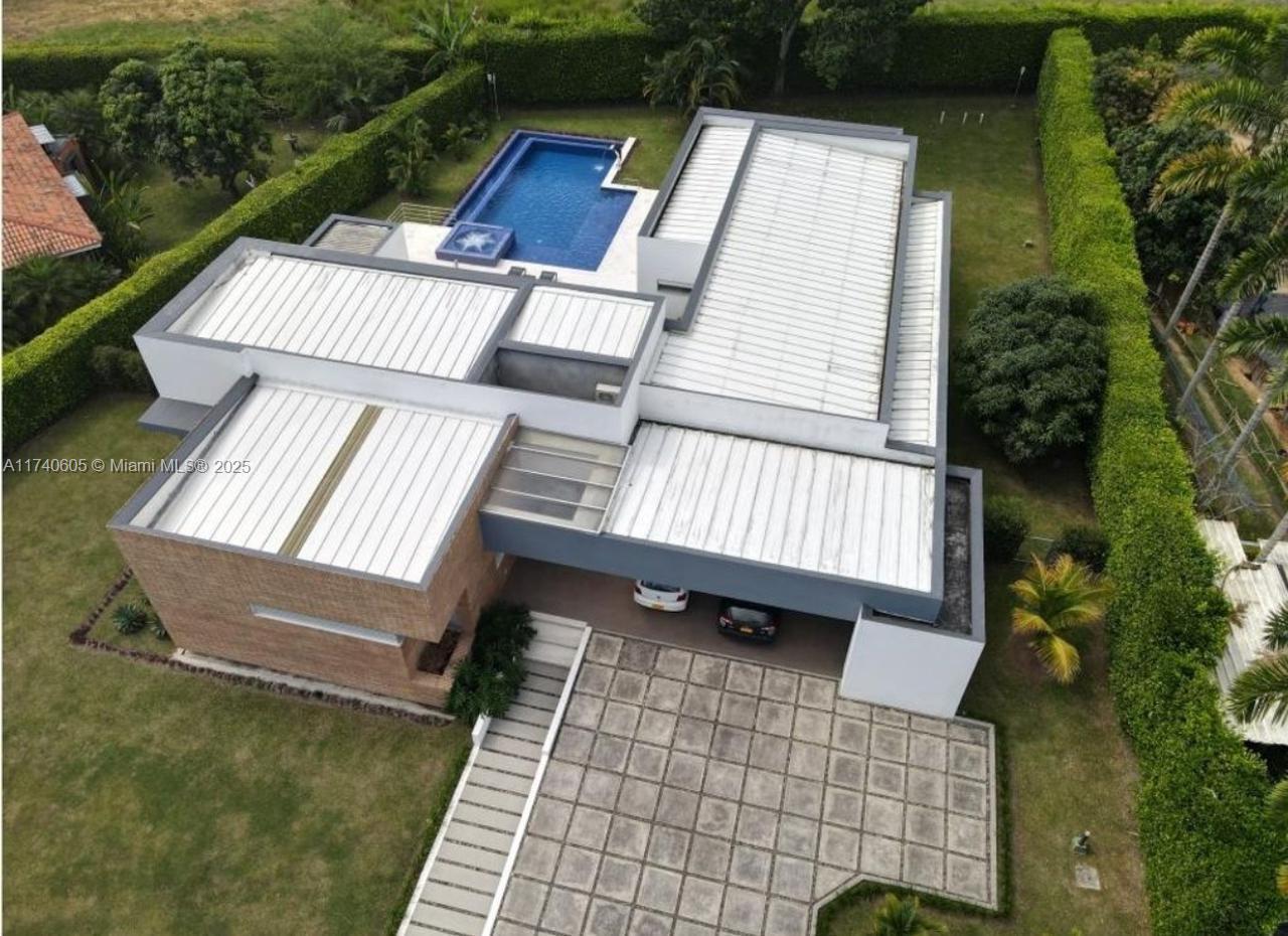 An aerial view of a modern house with a flat roof, swimming pool, and paved driveway — OTHER COUNTRY - NOT IN USA, PP