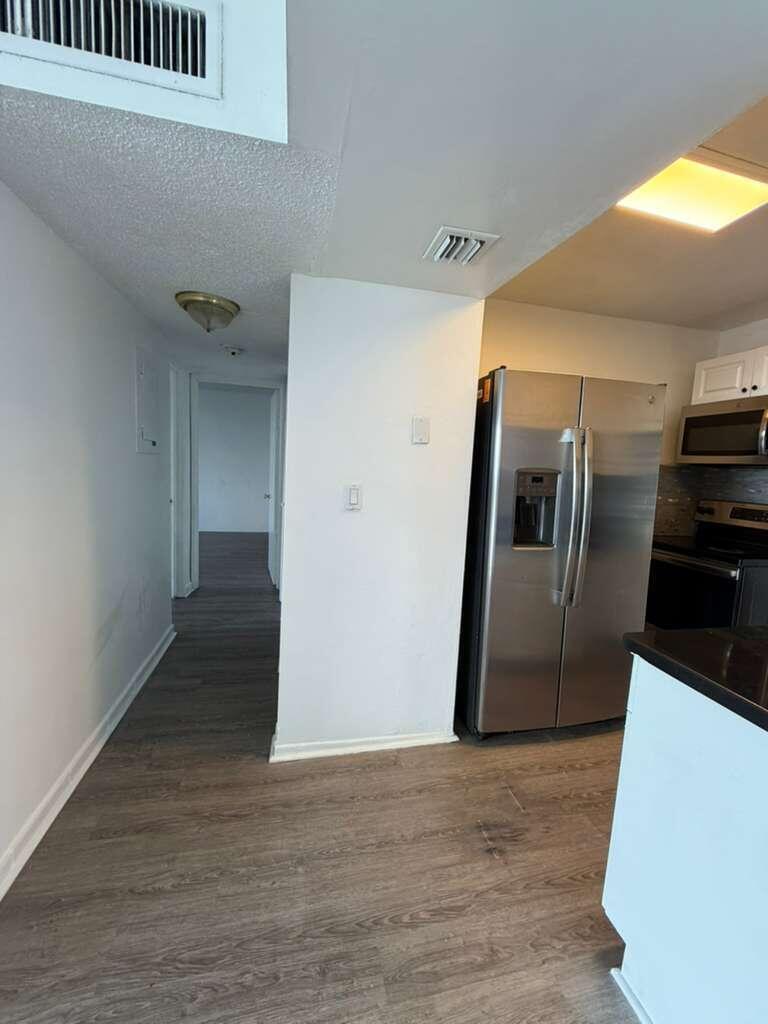 A view of a kitchen with stainless steel appliances and a hallway leading to rooms — 9682 Fontainebleau Boulevard # 603, Miami FL 33172, MIAMI, FL