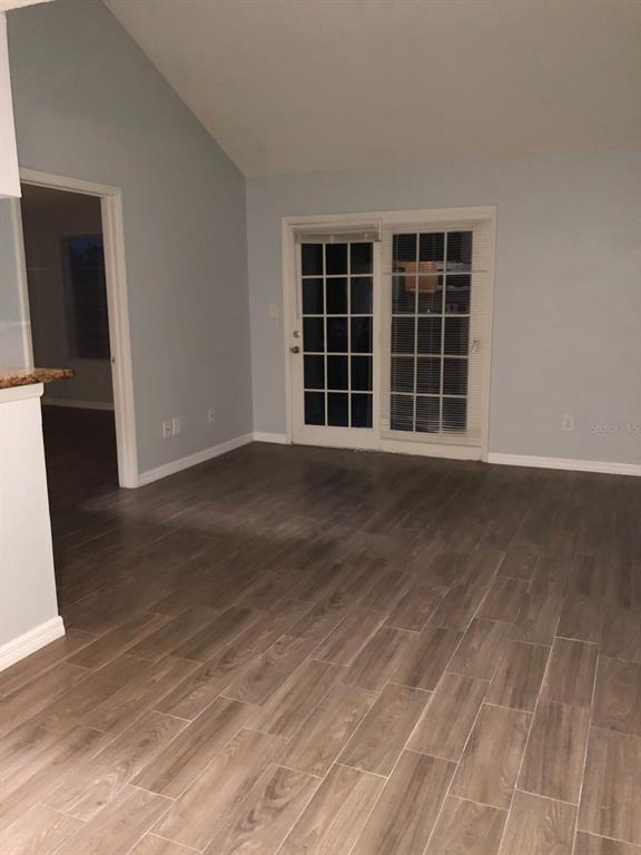 A room with light blue walls, wood-look tile flooring, and a glass-paned sliding door — 224 AFTON SQUARE UNIT 304, ALTAMONTE SPRINGS, FL