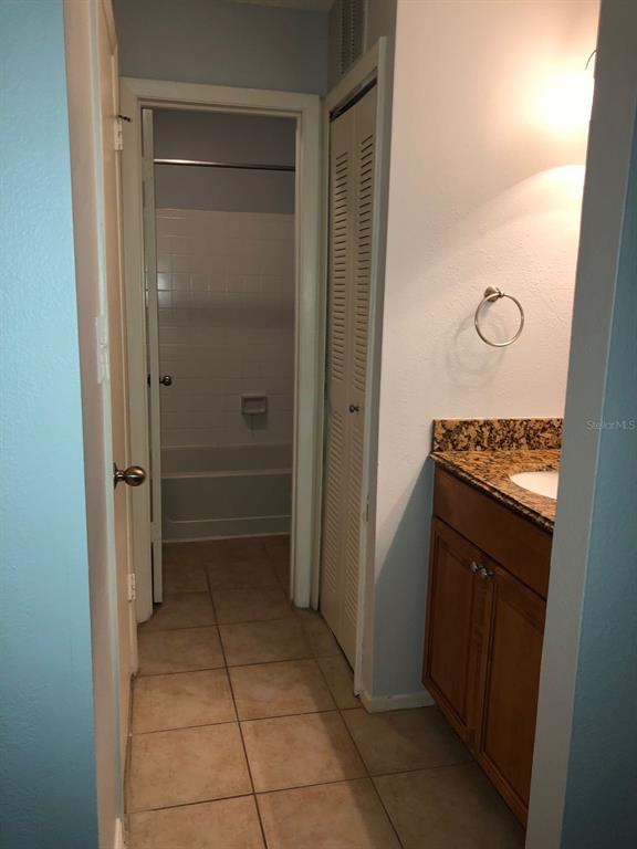 A bathroom features a vanity with a granite countertop, tile flooring, and a separate tub area — 224 AFTON SQUARE UNIT 304, ALTAMONTE SPRINGS, FL