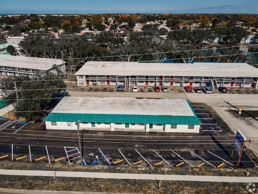 An aerial view shows two commercial buildings with parking lots and a nearby lake — 6609 RIDGE ROAD UNIT 2&4, PORT RICHEY, FL