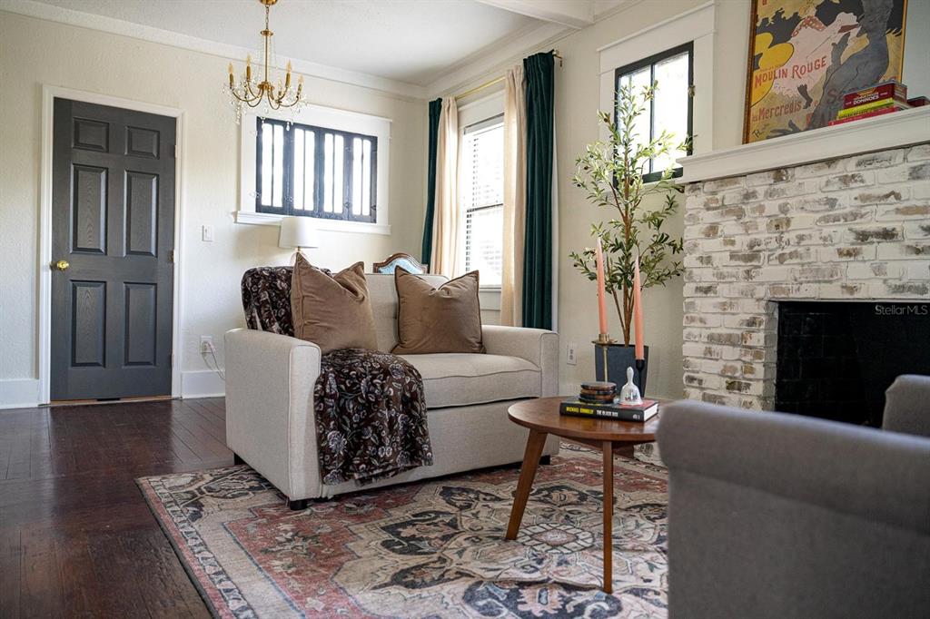 A living room features a white brick fireplace, a beige armchair, and a patterned area rug — 310 E ANDERSON STREET, ORLANDO, FL