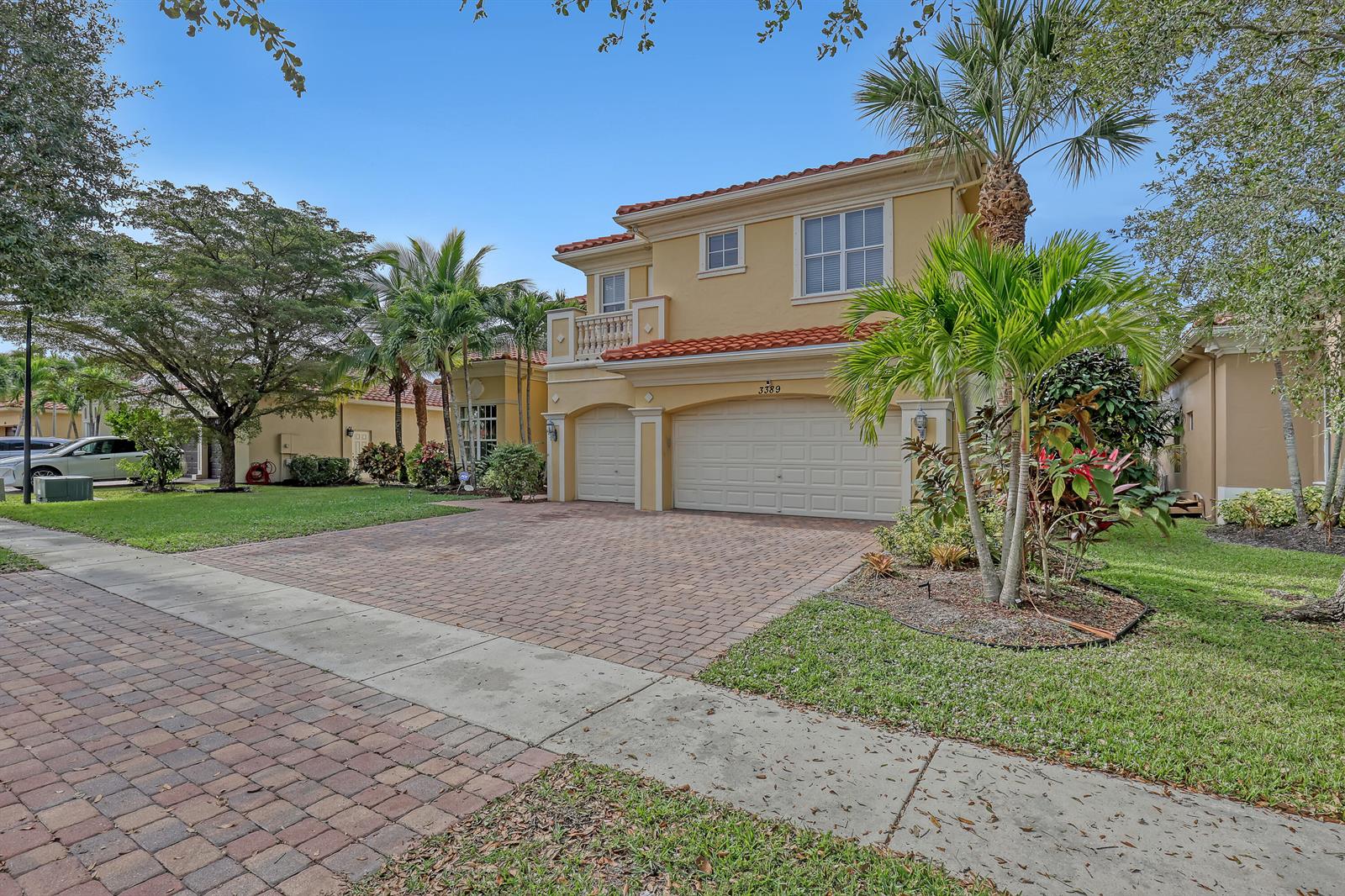 A two-story yellow stucco house with a red tile roof and a paved driveway — 3389 Lago De Talavera, Lake Worth FL 33467, LAKE WORTH, FL