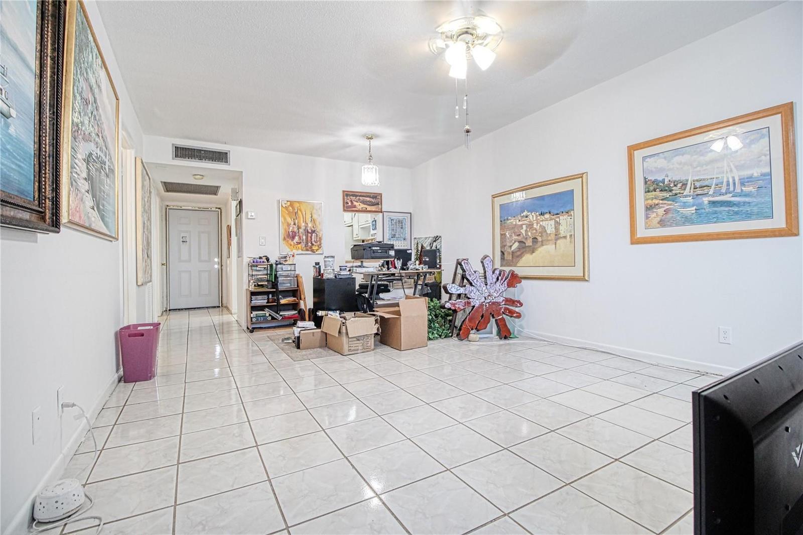 A living room with white tile floors, a ceiling fan, and several framed wall paintings — 2300 Park Lane # 311, Hollywood FL 33021, HOLLYWOOD, FL