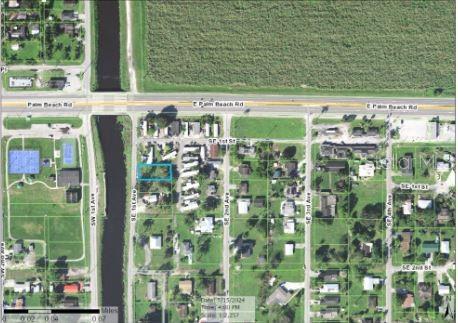This aerial map shows a residential lot outlined in blue near a canal and road — 205 SE 1ST AVENUE, SOUTH BAY, FL