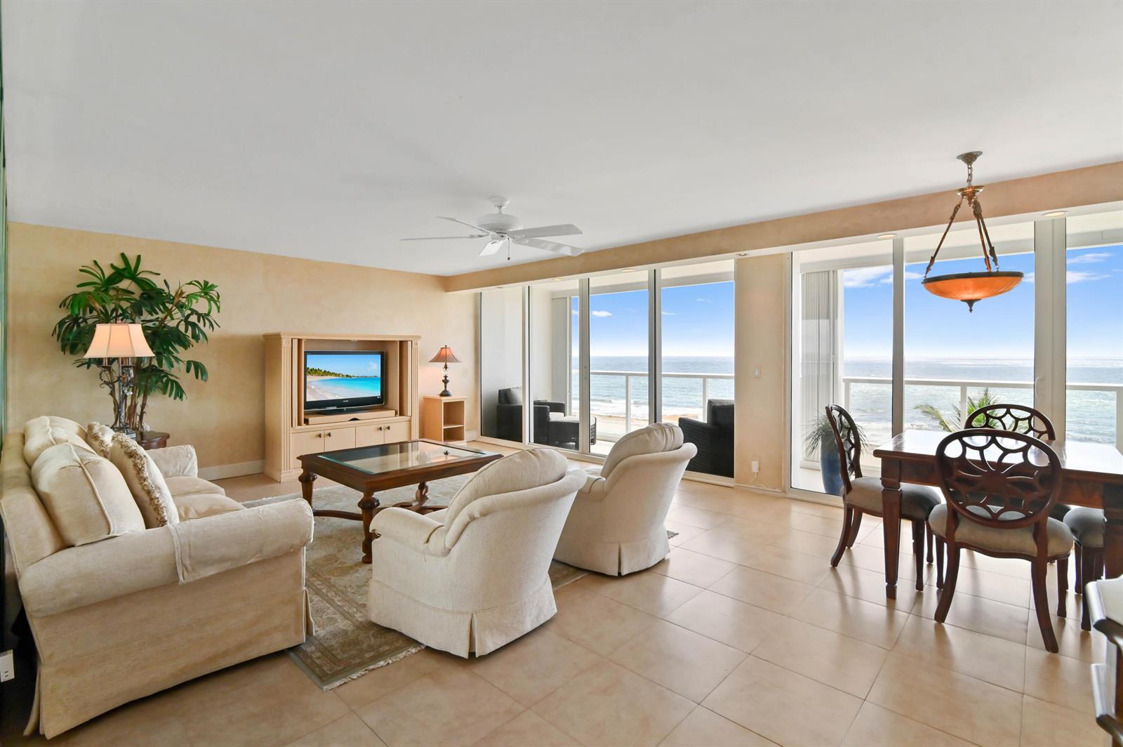 A living and dining area with beige tile floors, neutral furniture, and floor-to-ceiling ocean views — 2800 S Ocean Boulevard Apt j, Boca Raton FL 33432, BOCA RATON, FL