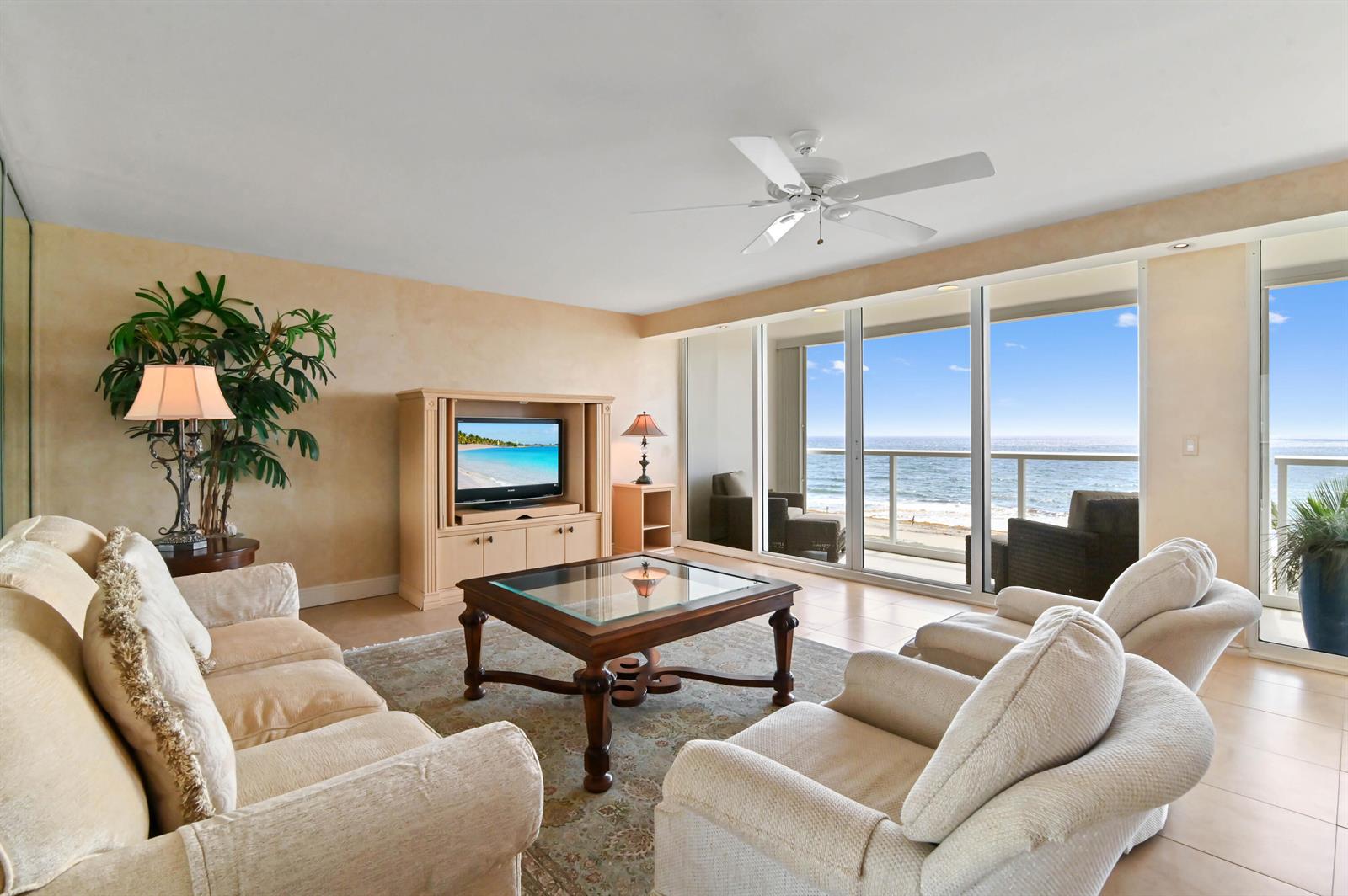 A living room features beige furniture, a glass-top coffee table, and sliding doors overlooking the ocean — 2800 S Ocean Boulevard Apt j, Boca Raton FL 33432, BOCA RATON, FL