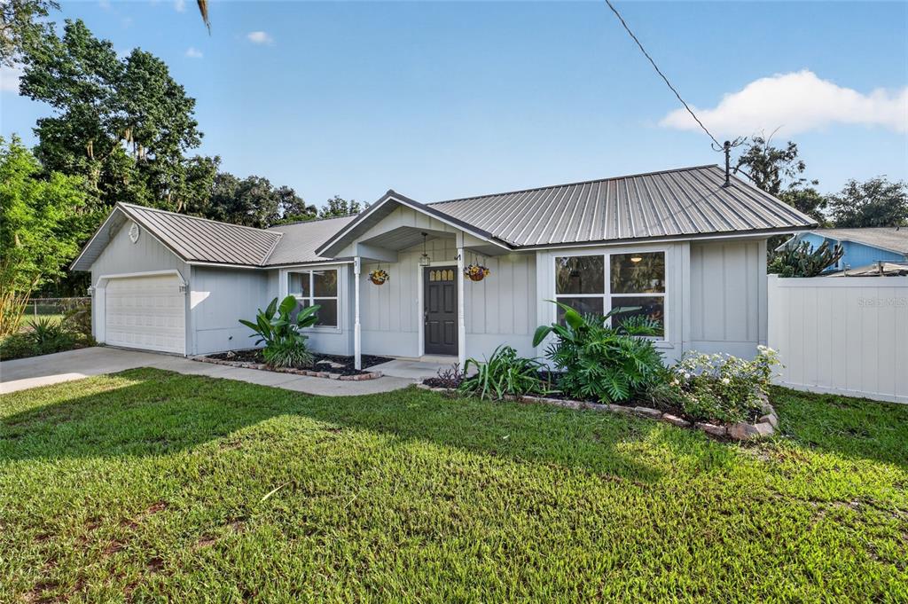 A single-story house with a metal roof, gray siding, and a two-car garage — 4861 SE 31ST TERRACE, OCALA, FL