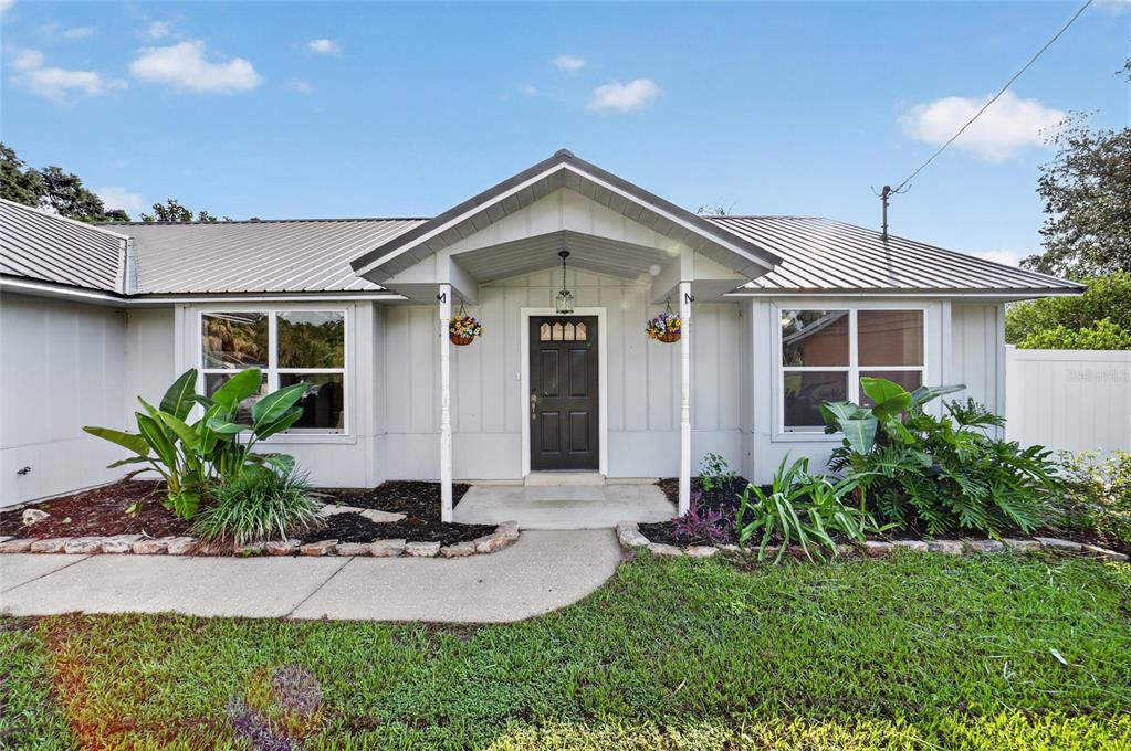 A single-story house with a metal roof, a covered entryway, and a front lawn — 4861 SE 31ST TERRACE, OCALA, FL