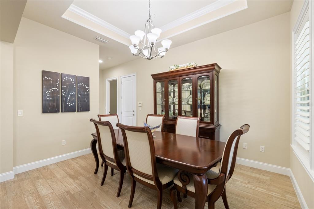 A dining room features a wooden table, six chairs, a hutch, and a chandelier — 2529 SW 118TH TERRACE, GAINESVILLE, FL