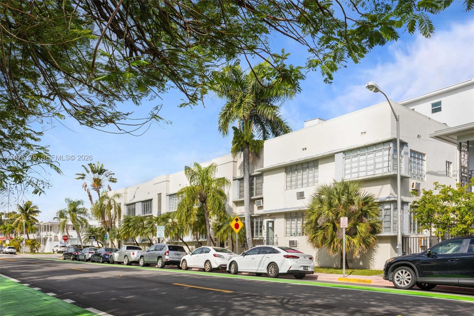 A street-level view of a multi-story white apartment building with palm trees and parked cars — 531 16th St, Miami Beach FL 33139, MIAMI BEACH, FL
