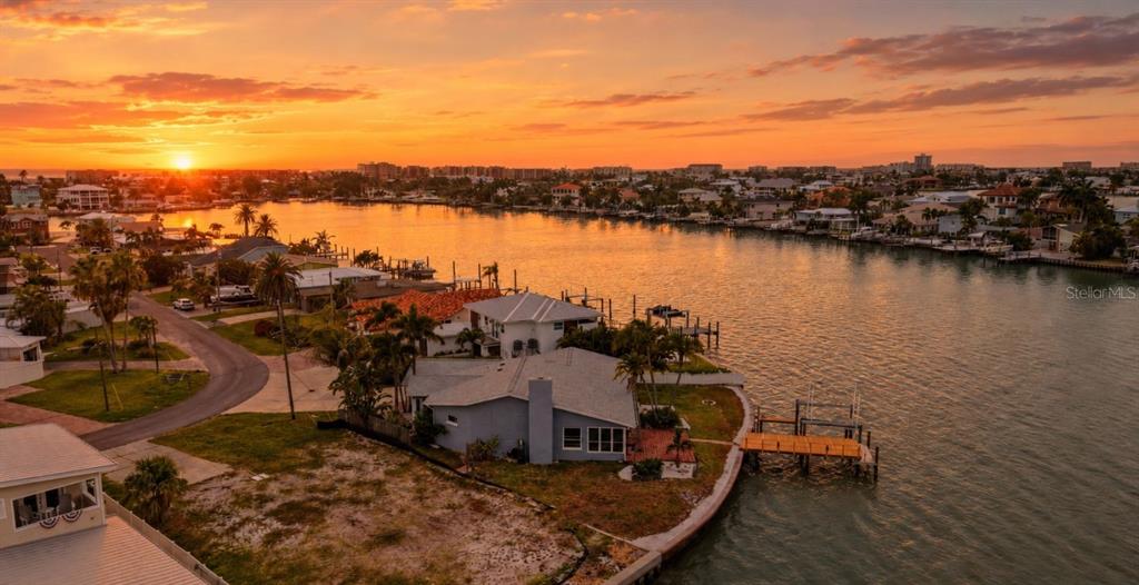 An aerial view of a waterfront house with a private dock at sunset — 16115 4TH STREET E, REDINGTON BEACH, FL