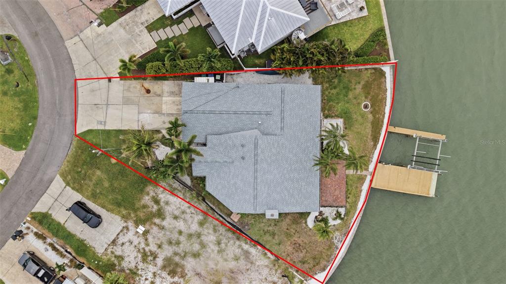 An aerial view shows a house with a gray roof on a waterfront lot — 16115 4TH STREET E, REDINGTON BEACH, FL